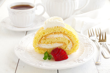 Biscuit roll with strawberry jam, and strawberries.