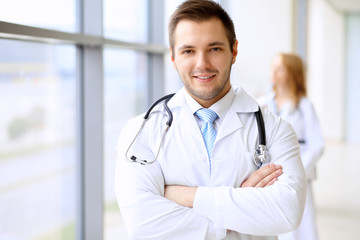 Smiling doctor waiting for his team while standing upright