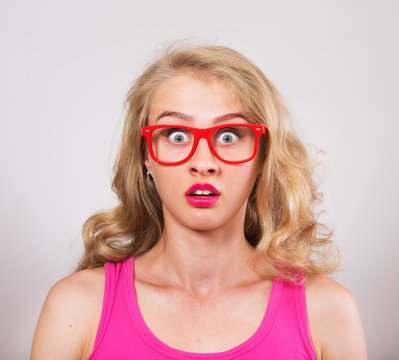 Funny surprised girl in red eyeglasses