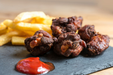 Chicken wings with sauce and golden French fries potatoes