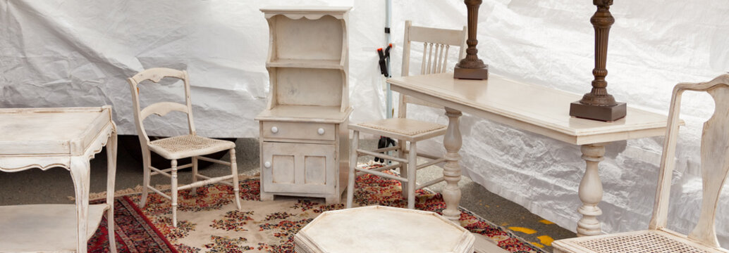 Vintage white shabby chic furniture on display at a flea market