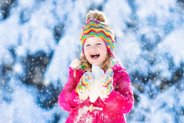 Fototapeta na wymiar Child having fun in snowy winter park