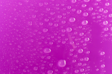Background of water droplets on the surface in purple colors