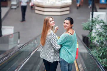 Women with bags on the moving staircase