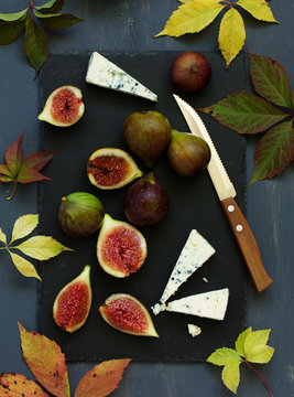 Fresh figs with cheese Dor Blue on gray board.