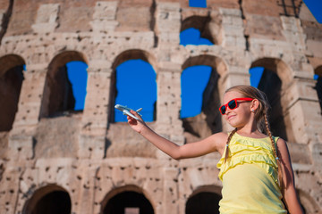 Fototapeta na wymiar Adorable girl with small toy model airplane background Colosseum in Rome, Italy