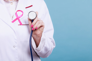 Pink ribbon with stethoscope on medical uniform.