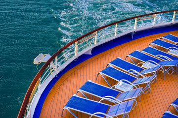 Blue sunbeds on a deck of a cruise ship - obrazy, fototapety, plakaty