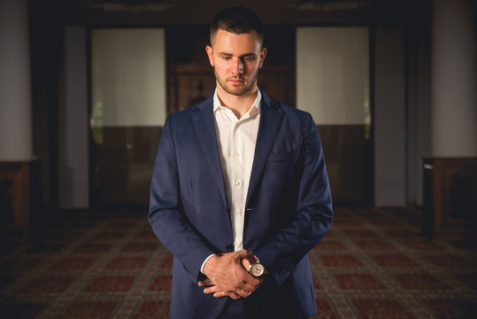 Young Muslim man praying in a mosque.