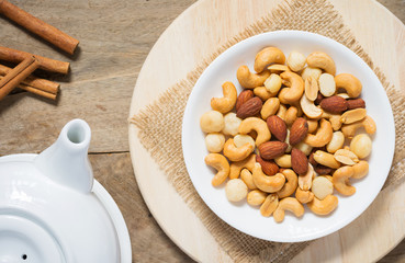 Salted cocktail nuts and cashews in white bowl with various nuts