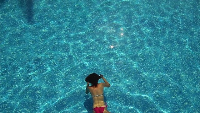Woman swimming across the pool underwater.
