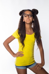 Emotional young brunette girl with long hair in yellow shirt and glasses on a white background