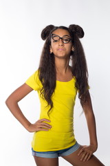 Emotional young brunette girl with long hair in yellow shirt and glasses on a white background