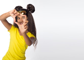 Emotional young brunette girl with long hair in yellow shirt on a white background