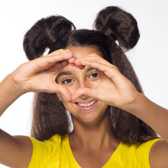 Emotional young brunette girl with long hair in yellow shirt on a white background