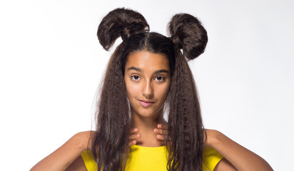 Emotional young brunette girl with long hair in yellow shirt on a white background