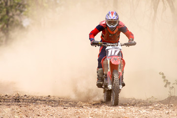 Motocross rider accelerating in dust track