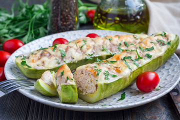 Zucchini boats stuffed with ground meet on a plate, horizontal
