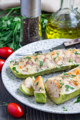 Zucchini boats stuffed with ground meet on a plate, vertical