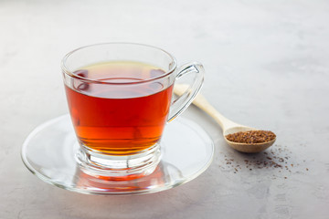 Healthy herbal rooibos red tea in glass cup, copy space