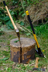 two ax in stump with wood crest on a background of green grass a
