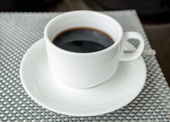 Obraz na płótnie Canvas Black coffee in white ceramic cup on table