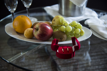 Обручальные кольца в коробочке на фоне фруктов