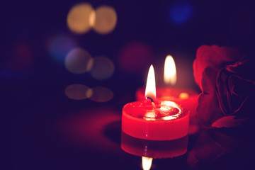 still life red candle light with reflection on dark stone ,abstract background for pray or meditation caption.
