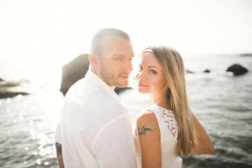 Obraz premium happy just married young wedding couple celebrating and have fun at beautiful beach sunset