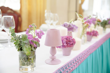 Small pink lamps as a part of dinner table decoration