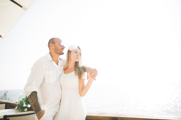 Just married wedding couple walking on the beach at sunset.