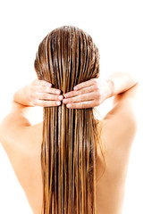 Woman applying hair conditioner. Isolated on white.