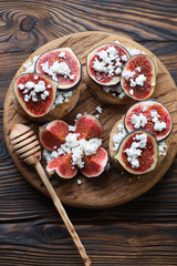 Bruschettas with figs on a wooden rustic serving board, top view