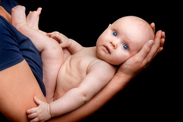 Newborn baby in the mother hands isolated on black