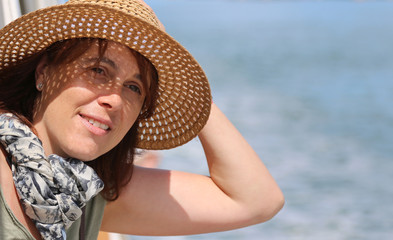 cute forty year old woman with straw hat on the cruise ship