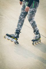 Rollerskater inline in action. Male legs shod in roller skates ride along the promenade
