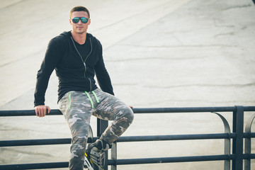 young fit man with inline skates rest in summer park after workout outdoor rollerskater