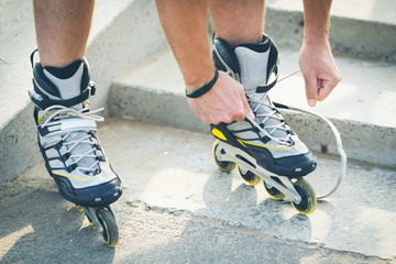 Man preparing for roller skating, putting on rollerskates