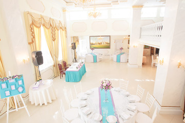 Restaurant hall prepared for a festive dinner and dressed in pin