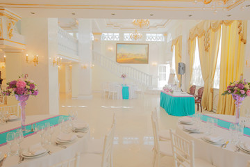 Tables stand ready for a festive dinner in rich restaurant hall