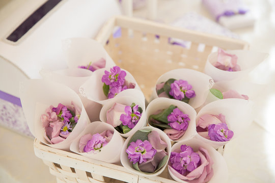 Basket with white envelopes full of violet flower petals