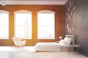 Sunlit bedroom with large clock and armchair in New York