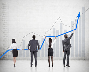 Four people holding a graph