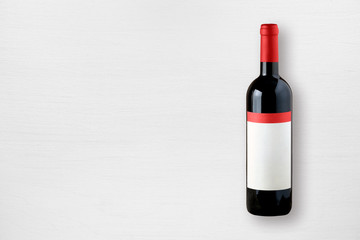 Red wine bottle on white table top view