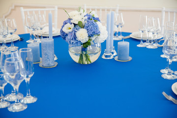 Festive table decoration in blue tones. Bouquet of blue hydrange