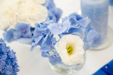 Table decor. Blue and white flowers in glass vases