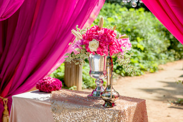 Golden lamp sparkles in the morning sun standing behind a pink b