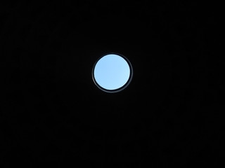 Output is always there. Photo symbolizes that any situation can be find a way out. Through a round hole on a black background can be seen the blue sky.