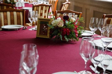 Dinner table decoration. Red bouquet and table number stands in