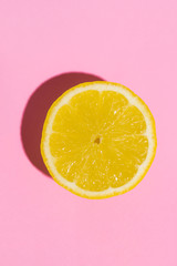 Lemon isolated on pink background. Minimal concept. Flat lay.